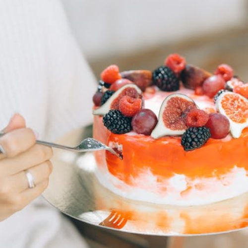 pexels-photo-5426079-5426079 Close-up of a fruit-decorated cake with cream and fresh berries, perfect for celebrations.